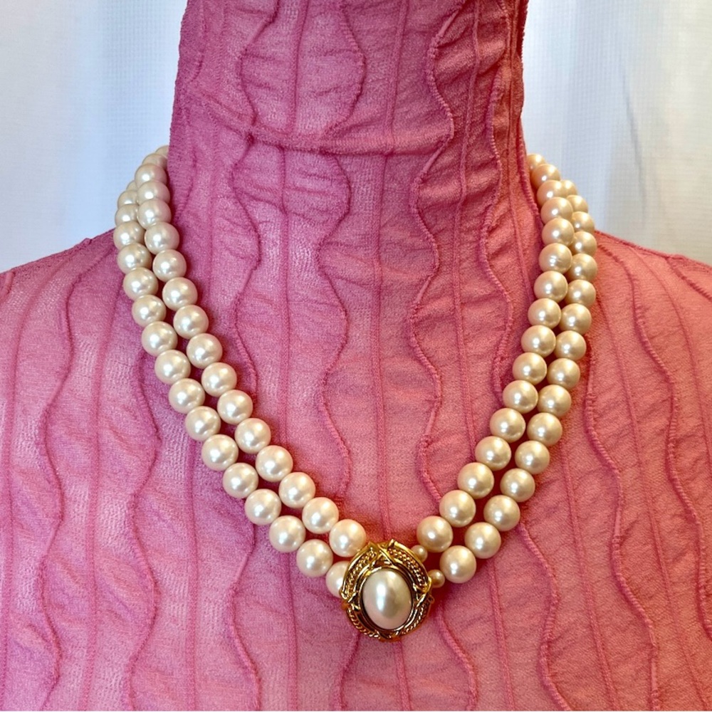 Vintage double-strand faux pearl necklace with a decorative front clasp.